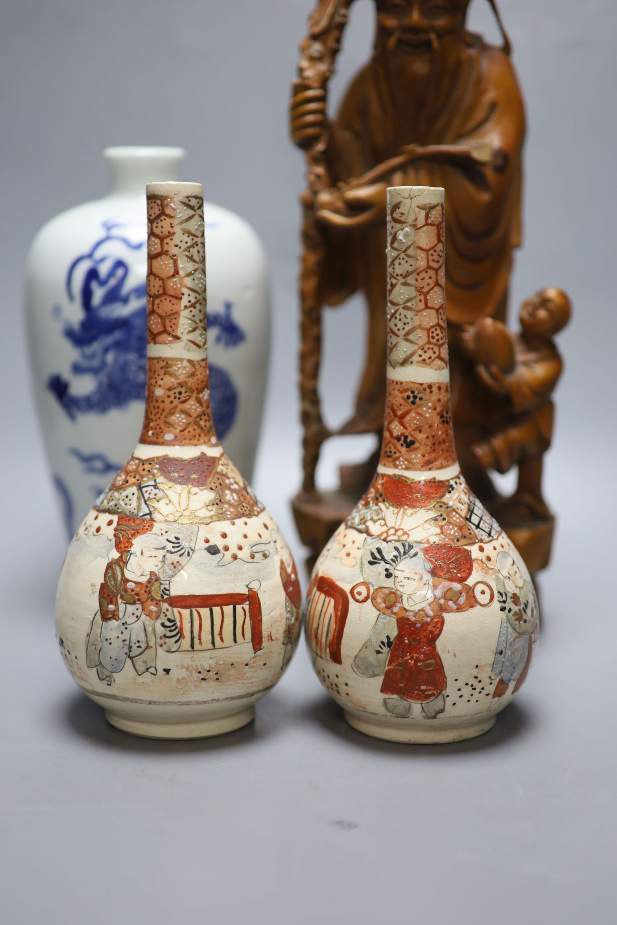 A pair of Satsuma bottle vases, a Chinese blue and white dragon vase, 22cm, and a hardwood carving of Shou Lao, height 37cm